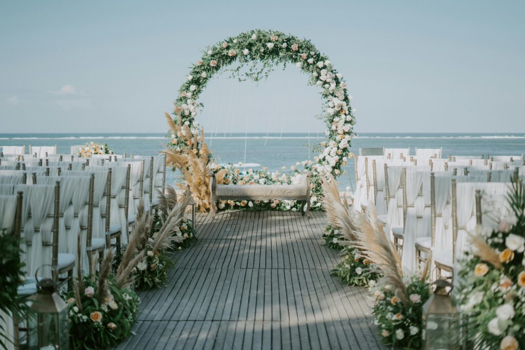 Arco floral vere con detalles blancos para boda en la playa.