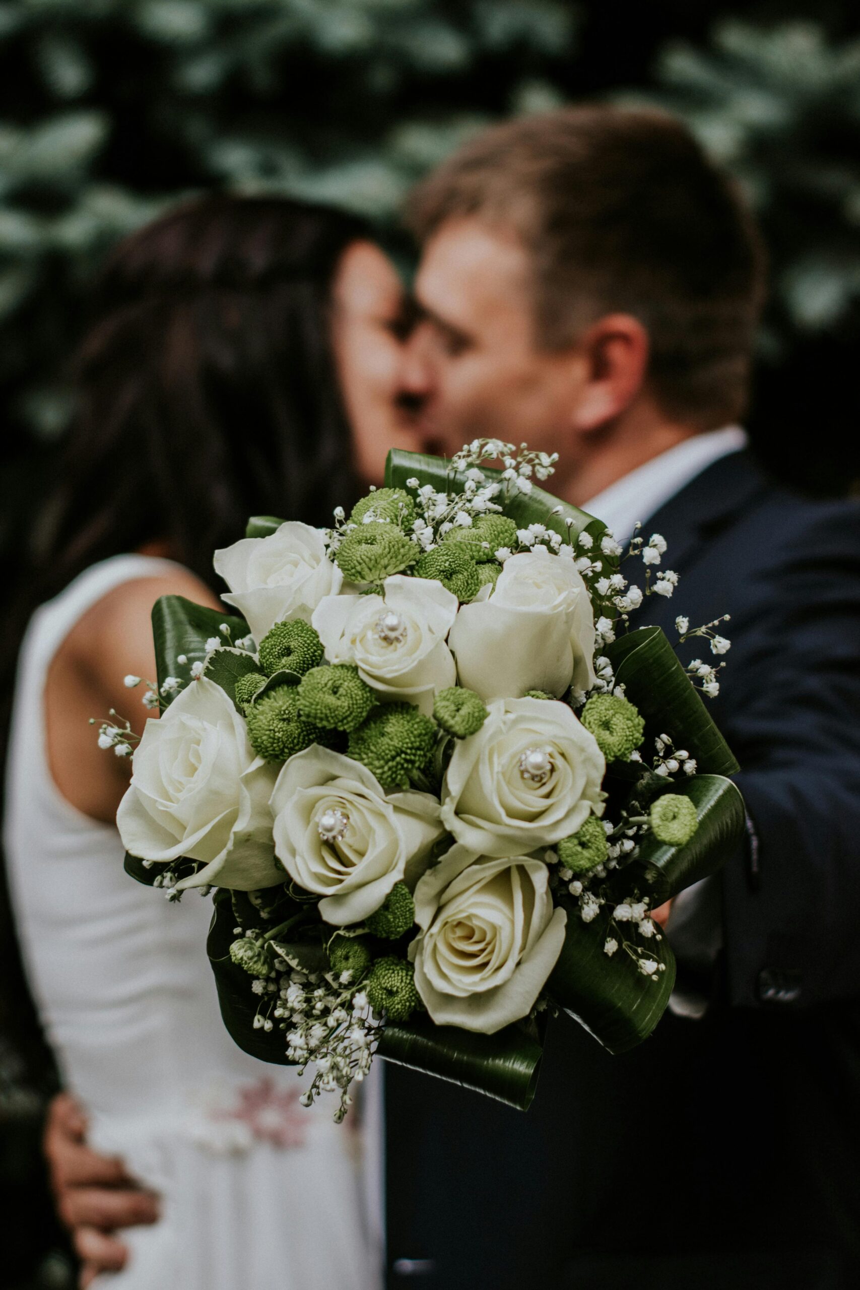 Ramo de novia con rosas blancas y flores verdes con detalles de hojas. Forma redonda