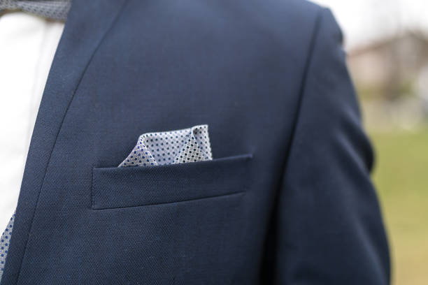 novio con traje azul oscuro y detalle de pañuelo color gris con puntos negros