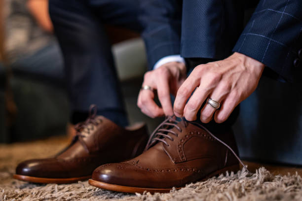 Novio con traje azul oscuro y zapatos marrones de cordones