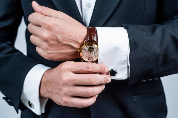Novio con traje negro y reloj de cuero marrón y esfera blanca