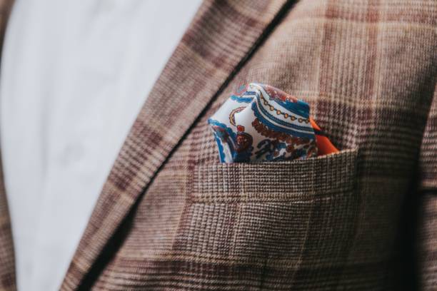 novio con traje a cuadros en tonos marrones con detalle de pañuelo blanco estampado en color azules y rojizos
