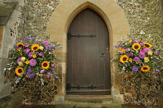 entrada a la iglesia decorada con flores, girasoles y follaje, decoración iglesia con flores, decoración flores, decoración boda