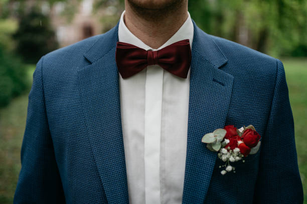 Novio con traje azul jaspeado y pajarita en color granate