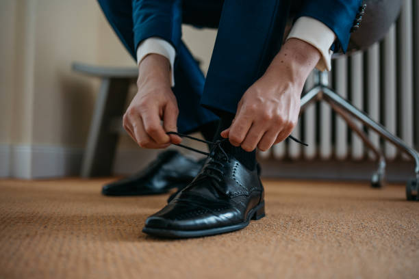 Novio con traje azul marino oscuro y zapatos negros de cordones