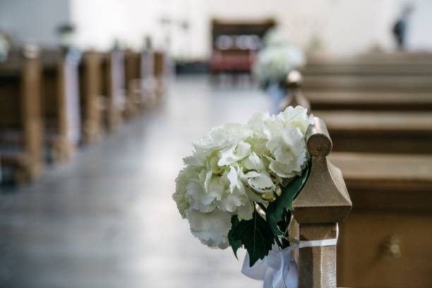 decoración bancos iglesia. Decoración con flores blancas y lazos