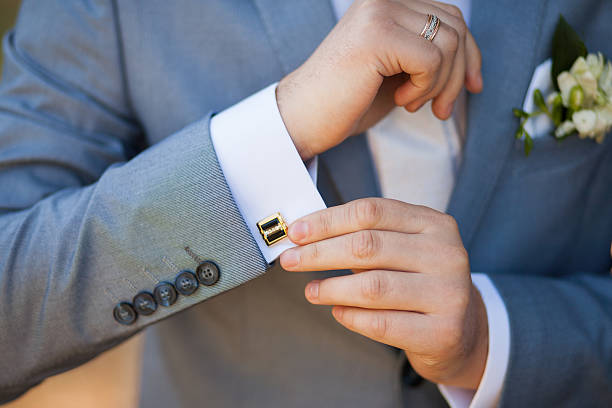 Novio con traje gris y gemelos de color negro con detalles en oro