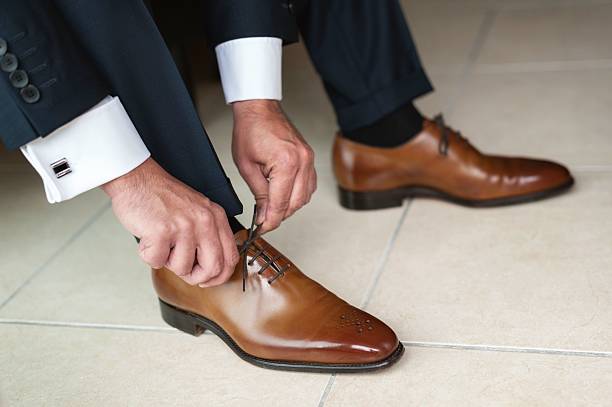 Novio con traje negro y zapatos marrones de cordones