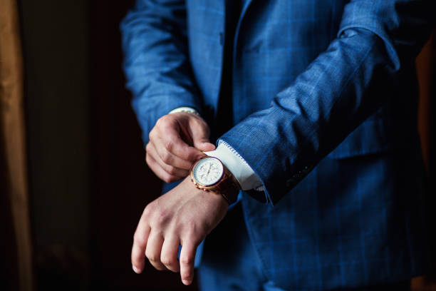 Novio con traje azul y reloj con acabado blanco y marrón